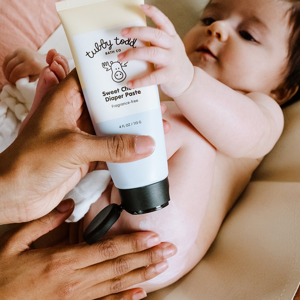 Mom is applying the sweet cheeks diaper paste to her baby's cheek
